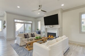 Primary living room features dual sofas, a TV, and a fireplace.