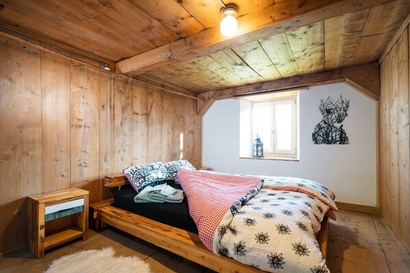 The rustic bedroom exudes the charm of the house