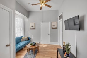 Stylish & Functional Decor
Minimalist design meets function with a low-profile entertainment unit, decorative plants, and wood-style flooring throughout.