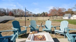 Relaxing outdoor space with a fire pit, volleyball net, and comfortable seating.