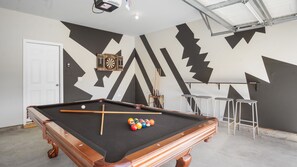 Stylish billiards room with a professional pool table and seating for four.