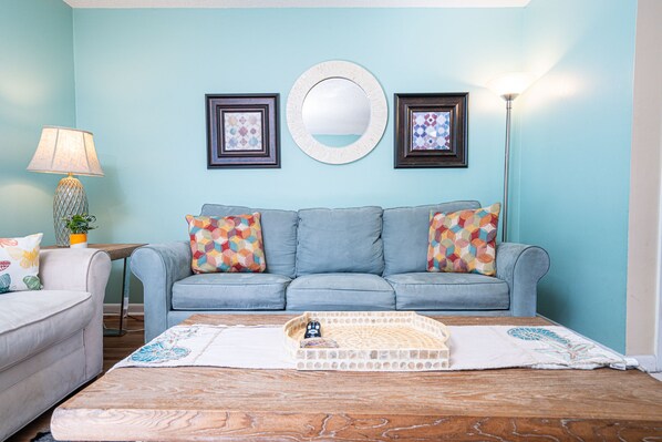 Living Room: Bright and inviting, with a splash of color and serene nature views!