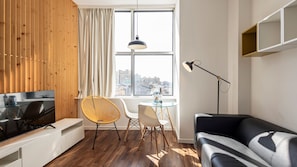A spacious living room with abundant natural light, featuring a large window that offers a view of the outdoors #city #airbnb