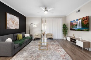 Living area with sofa, table, TV and additional seating