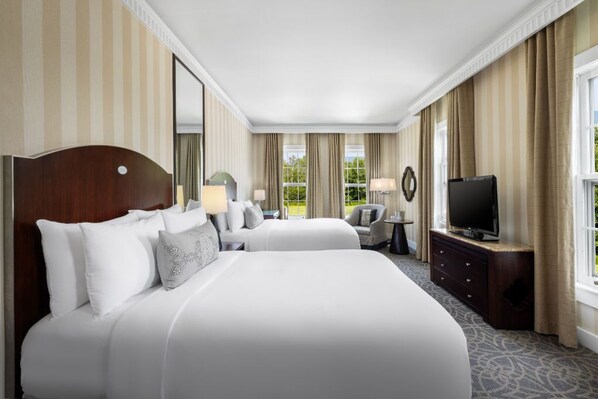 A grand bedroom that pairs comfort with sophistication, featuring plush linens and a tranquil lounge space.
