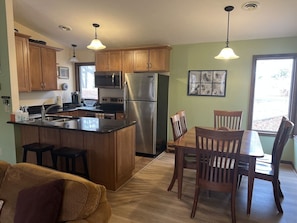 Kitchen w/ eat in bar and dining room area w/ six spots 