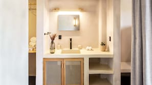 Master bathroom with a luxurious shower, fully equipped with premium amenities including shampoo, conditioner, body soap, and plush towels.