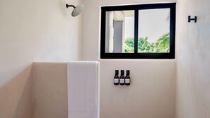 Master bathroom with a luxurious shower, fully equipped with premium amenities including shampoo, conditioner, body soap, towels.