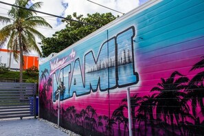Our dazzling "Welcome to Miami" mural bursts with Miami Vice hues. A vibrant scene unfolds— a girl on a jetski skimming turquoise waves against the iconic Miami skyline. A vivid tribute capturing the city's energy and coastal allure.