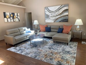 Wonderful sky lights light up this living room creating a lovely comfortable place to sit and enjoy the view or a fire in the fireplace.