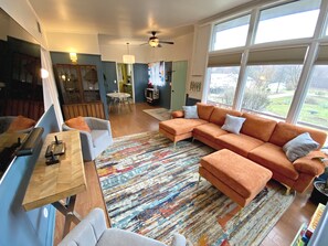 Open living room into the dining area.  70" smart TV with an Atari.
