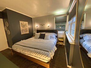 Primary bedroom with a king bed, dresser, & large closet.