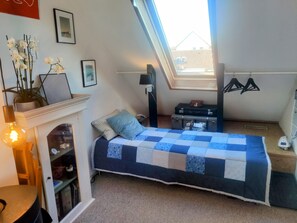 The single bed in the bed room with the door