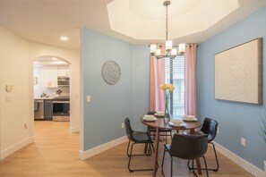 A cozy dining nook with a round table, modern chairs, and soft blue walls.