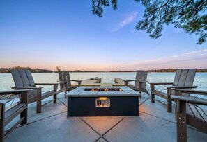 Gather and Unwind at this Tranquil Lakeside Firepit, Where the Gentle Glow Complements the Fading Dusk Over Calm Waters.