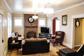 A cozy living room, thoughtfully furnished with comfort in mind. Sink into plush furniture and enjoy stay-home moments, enhanced by a sleek flat-screen TV—a perfect blend of relaxation and entertainment.