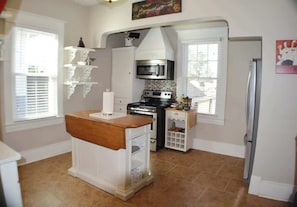 Discover culinary joy in a full kitchen—stove top oven, refrigerator, freezer, and a convenient microwave on a sleek countertop. Modern amenities harmonize seamlessly, creating a culinary space where convenience meets contemporary living.