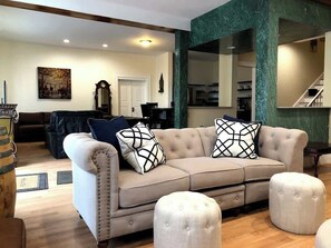 A cozy living room adorned with tasteful furniture, plush pillows generously scattered across a gleaming hardwood floor, providing a warm and inviting ambiance.
