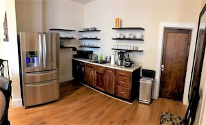 In a cozy kitchen, a gleaming metallic refrigerator-freezer stands tall, its sleek design complemented by a countertop oven and another fridge-freezer, ready to make your culinary adventures come to life!