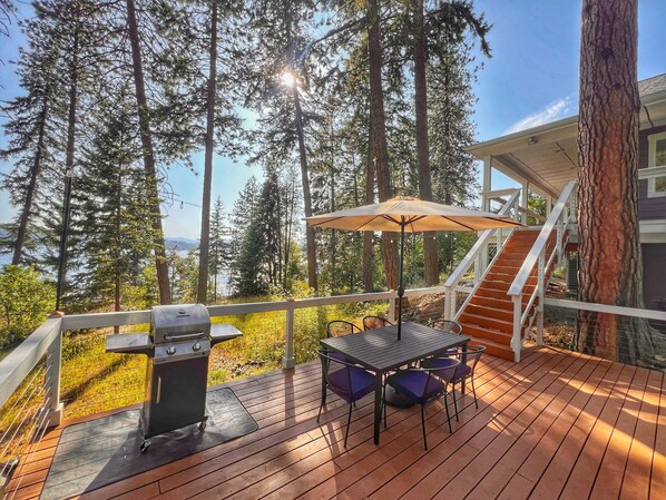 Lower deck with outdoor dining table and BBQ.