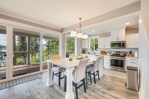 A beautiful kitchen with a big island, seating for 4, and 2 barstools. It’s equipped with a large fridge, gas oven, dishwasher, coffee maker, and microwave, making it easy to whip up your favorite meals during your stay. 