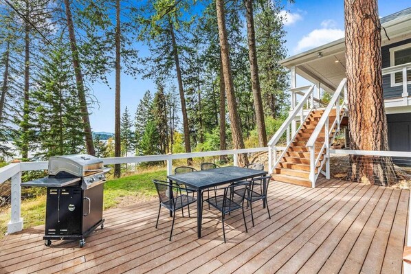 Lower deck with outdoor dining table and BBQ.