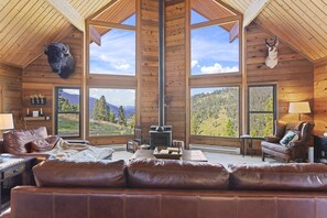 Main living room with woodstove and rocky mountain views