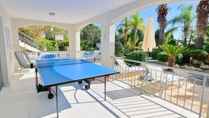 Shaded outdoor table tennis area.