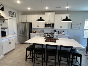 Kitchen with Stainless Steel Refrigerator, Microwave, Dishwasher and Gas Stove