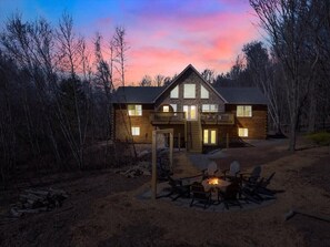 Oversized log cabin, faced with cobblestone overlooking the spacious firepit and beautiful Lake Sinca with unobstructed views.