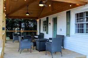 Charming covered front porch with comfortable seating and mountain views at Bailey Hot Springs. Covered porch perfect for reading or sipping wine while watching the sunset in Hot Springs, NC.