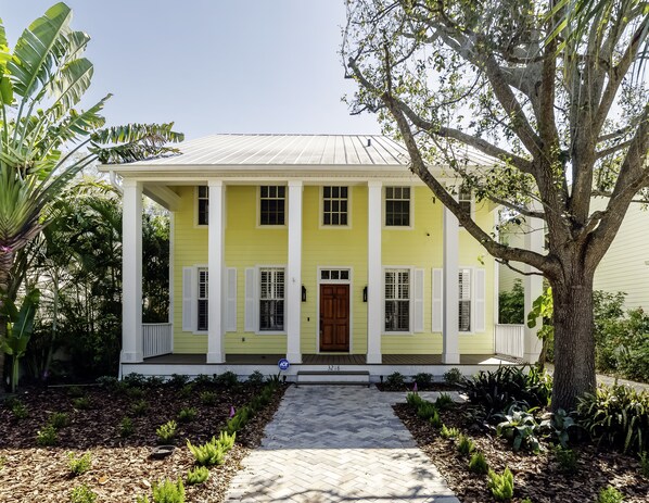 Pavers lead up to a beautiful Key West style front porch.