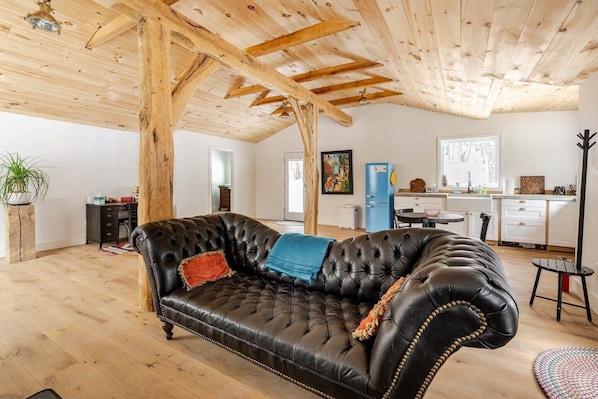 Hand hewn beams, wide plank white oak floors and a comfy sofa.