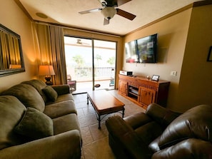 Living Space with sofa bed, 65" Roku SmartTV, and ceiling fan