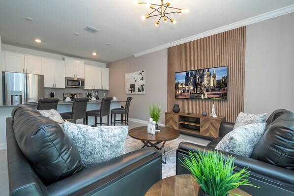 Welcome to our spacious and beautifully adorned living room, complete with a state-of-the-art smart TV where you can stream all your favorite channels and shows. 