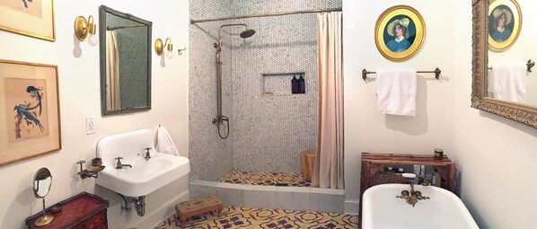 Large bathroom with Moroccan and marble tiles, clawfoot tub, and walk-in shower.