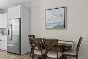 An inviting dining table nestled within a seamlessly integrated modern kitchen.
