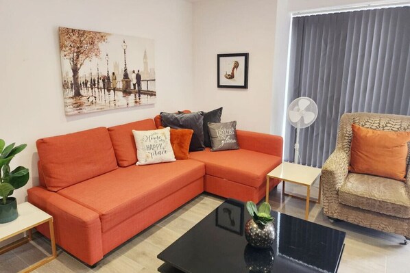 Living room with sofa bed and furniture with smart TV with Netflix. Professionally Managed by : GPSbnb