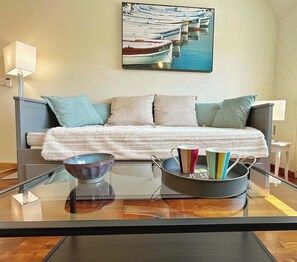 Cozy living nook featuring a convertible sofa bed, ensuring a restful sleep after a day spent sailing or surfing.