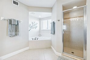 Indulge in the master bathroom featuring a relaxing jetted tub and a spacious walk-in shower for the ultimate spa-like experience.
