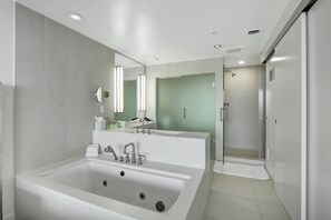 Primary En Suite Bathroom | Features a spa tub, shower, and toilet.