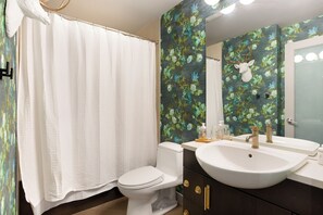 A stylish guest bathroom with trendy wallpaper and all essential amenities.