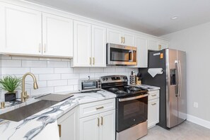 Prepare culinary delights in our fully equipped kitchen, featuring all cooking essentials and meal prepping necessities, along with convenient bar stool seating for casual dining.