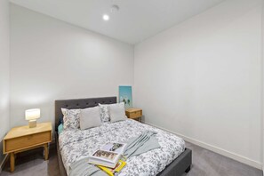 The 2nd bedroom with a queen sized bed & plush pillows.