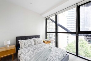 The master bedroom with a queen sized bed & plush pillows.