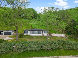 Eagles nest, amidst lush greenery, with a detached garage, front deck, and serene outdoor space, perfect for relaxation and enjoying nature's beauty.