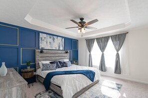 master bedroom featuring king size bed, tv, walk in closet, and private bathroom