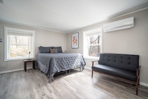 Comfortable bedroom with a king bed, wall-mounted TV, and modern minimalist decor!
