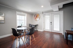 Bright dining area with modern furnishings, hardwood floors, and outdoor access!