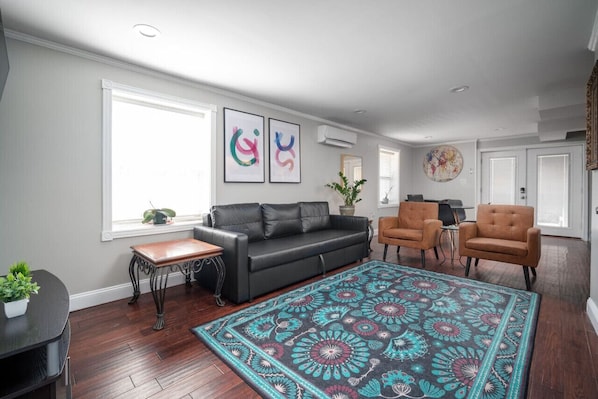 Modern, cozy living space with vibrant decor, comfy seating, and natural light!